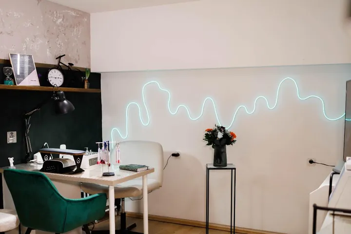 Maniküre-Platz mit grünem Samtsessel und Neonlicht